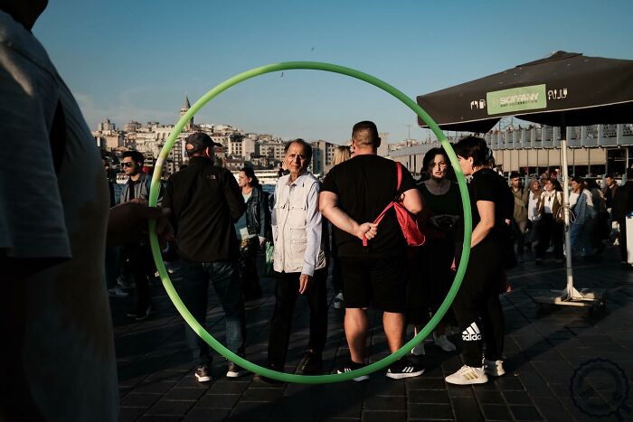 Street scene captured by Gökhan Arer, featuring a green circle framing people, creating a unique visual perspective.