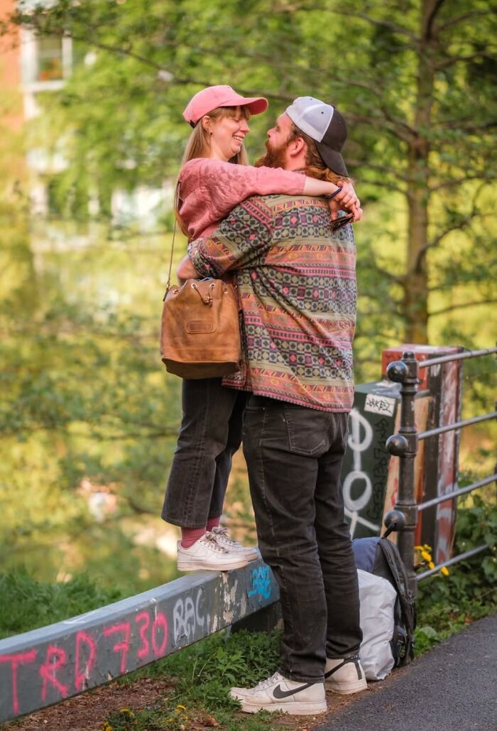 Couple embracing on a graffiti-covered railing in Oslo or Stockholm, capturing street essence.