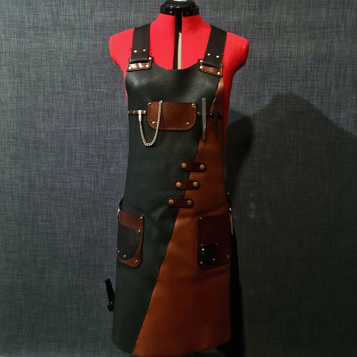DIY project: handcrafted leather apron on a dress form, featuring brown and black panels with pockets and metal accents.