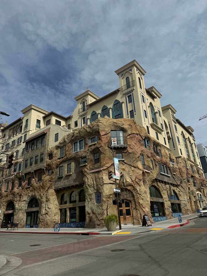 Multi-story building with rock-like façade blending natural textures and architectural design in an impressive architectural feat.