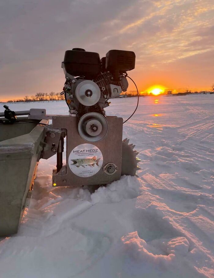 Ingenious redneck engineering showing a custom motorized device in snow at sunset on a frozen lake.