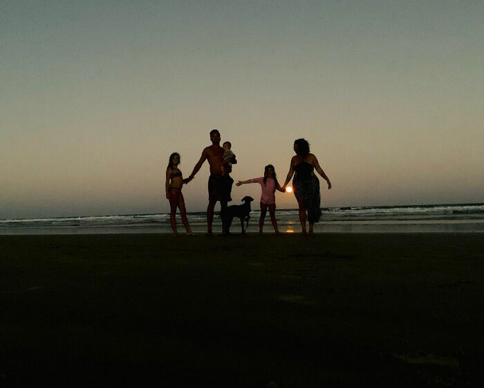 Family with a rescue dog at the beach during sunset, enjoying a peaceful moment together. Family with a rescue dog at the beach during sunset, enjoying a peaceful moment together.