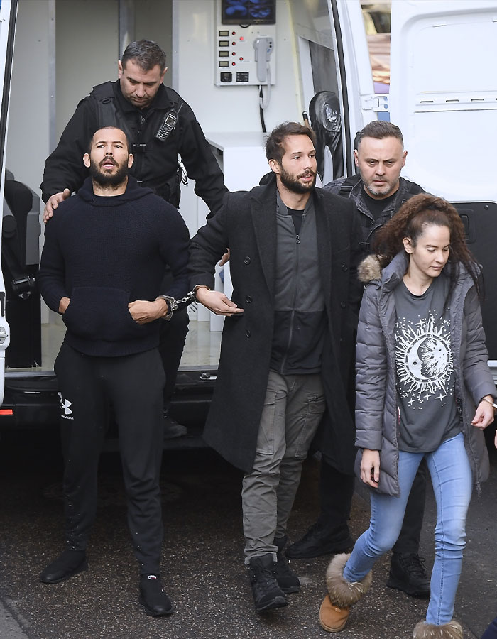 Individuals escorted by officers from a vehicle, related to trafficking charges in the US. Individuals escorted by officers from a vehicle, related to trafficking charges in the US.