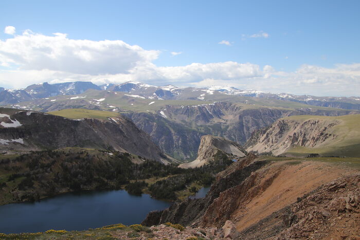 Scenic view of Beartooth Highway, showcasing rugged mountains and a pristine lake, featuring legendary American road routes.