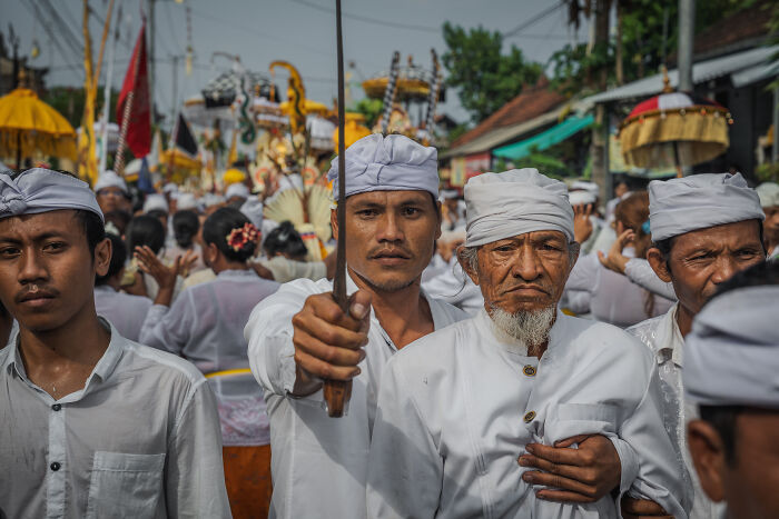 Balinese men in traditional attire during Galungan celebration procession.