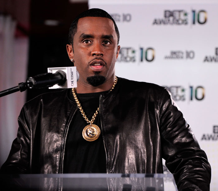 Man in black leather jacket speaking at a podium during an event, related to lawyer's trial quit. Man in black leather jacket speaking at a podium during an event, related to lawyer's trial quit.