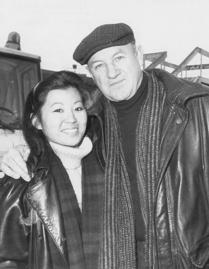 Two people in winter clothing, smiling, with a backdrop of a snowy outdoor scene, related to Gene Hackman investigators. Two people in winter clothing, smiling, with a backdrop of a snowy outdoor scene, related to Gene Hackman investigators.