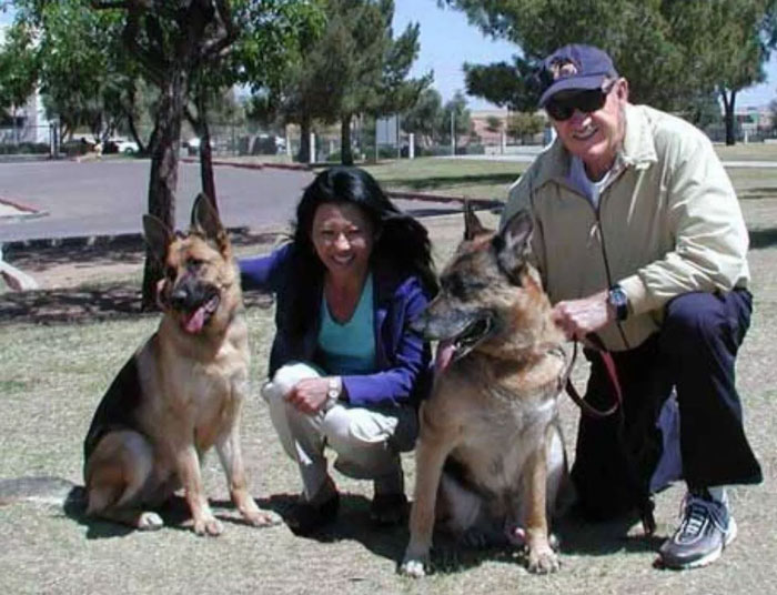 Two German Shepherds with people in a park, related to Gene Hackman investigators' update on dogs that survived. Two German Shepherds with people in a park, related to Gene Hackman investigators' update on dogs that survived.