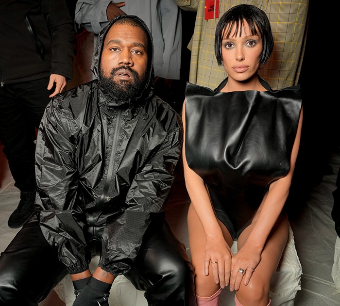 Bianca Censori and Kanye West seated together, wearing black outfits at a public event. Bianca Censori and Kanye West seated together, wearing black outfits at a public event.