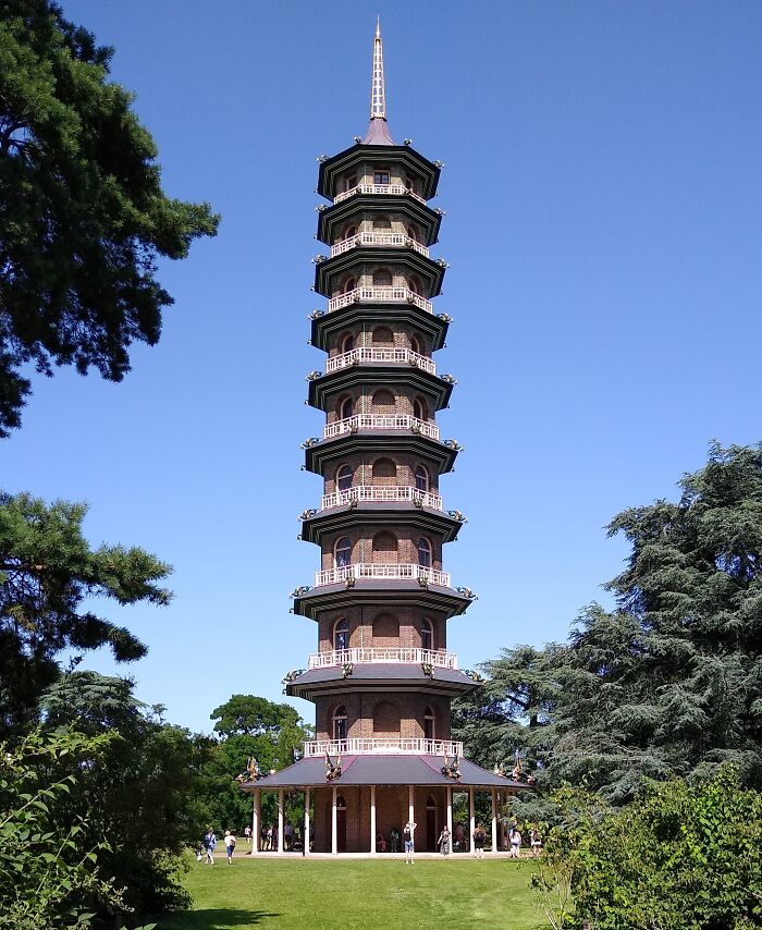 Tall pagoda-style building surrounded by trees, an example of beautiful useless architecture.