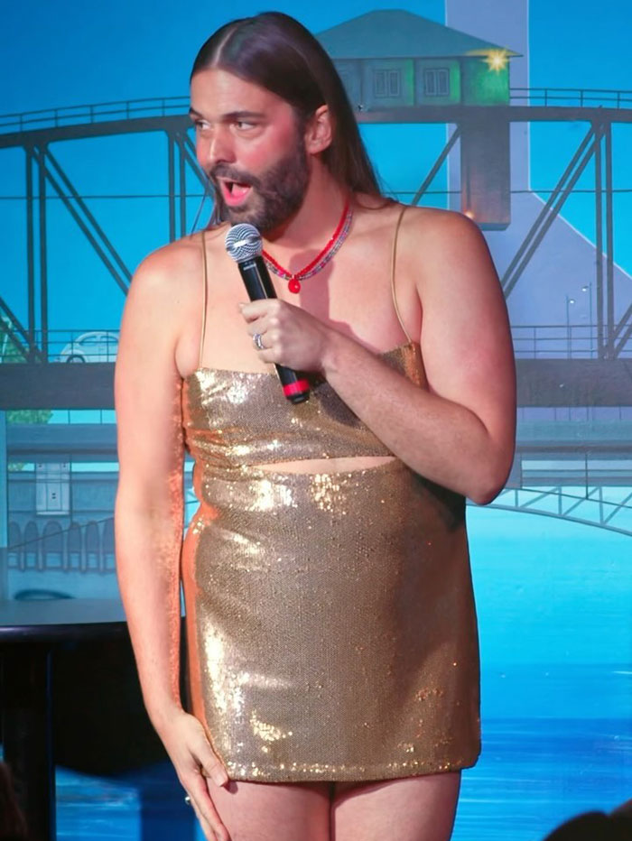 Queer Eye's Jonathan Van Ness on stage in a gold dress during a performance. Queer Eye's Jonathan Van Ness on stage in a gold dress during a performance.