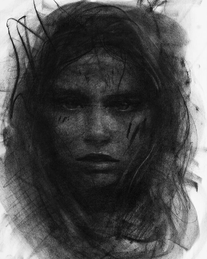 Charcoal portrait of a woman's face with intense expression, illustrating striking artistic style by Josh Hernandez.