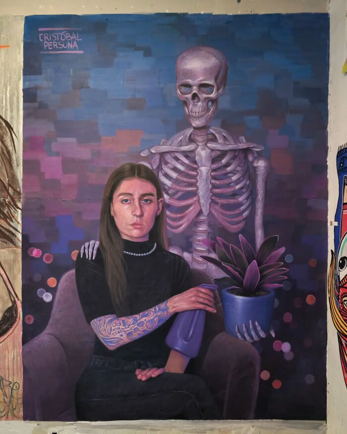Chilean artist mural of a woman with tattooed arm and skeleton holding a plant in a surreal scene.