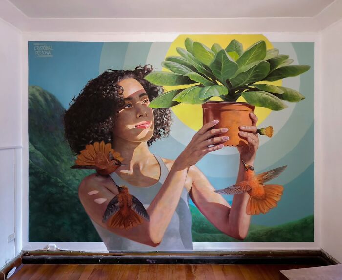 Chilean artist's mural of a woman holding a potted plant with hummingbirds around, set against a vibrant backdrop.