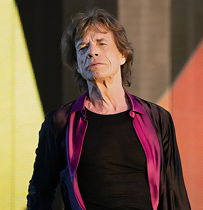 A person performing on stage, wearing a black shirt and purple open shirt, related to secret celebrity documents. A person performing on stage, wearing a black shirt and purple open shirt, related to secret celebrity documents.