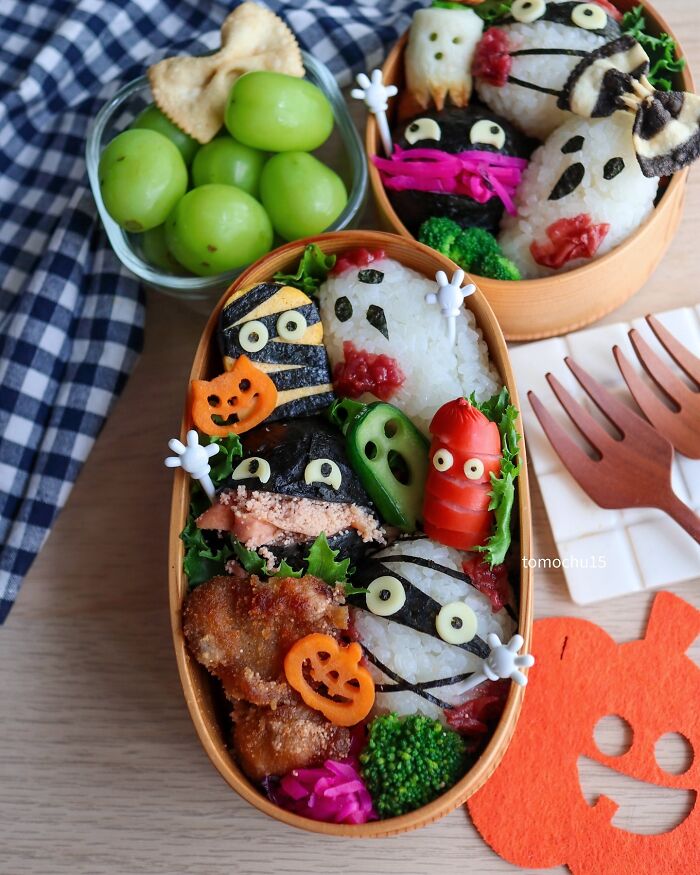 Creative lunchbox featuring Halloween-themed rice balls and vegetables by a talented Japanese artist.