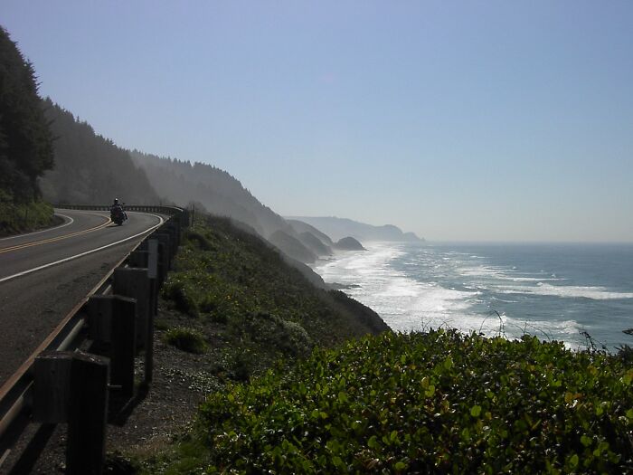 Scenic coastal view of a legendary American road route with ocean waves and cliffs in the background.