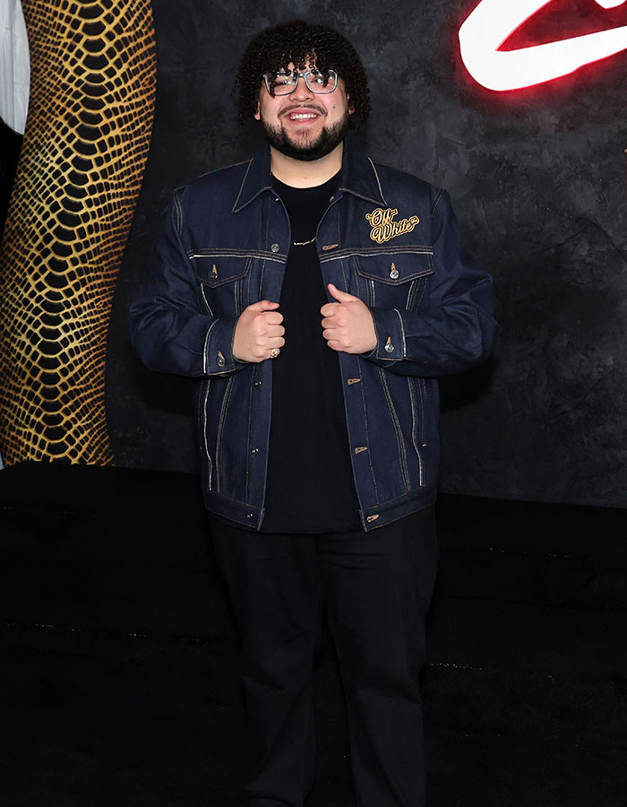 Unrecognizable actor in denim jacket on red carpet, smiling confidently. Unrecognizable actor in denim jacket on red carpet, smiling confidently.