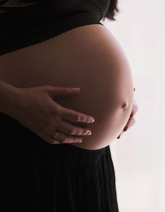 Pregnant woman holding her belly, symbolizing surrogacy and motherhood. Pregnant woman holding her belly, symbolizing surrogacy and motherhood.