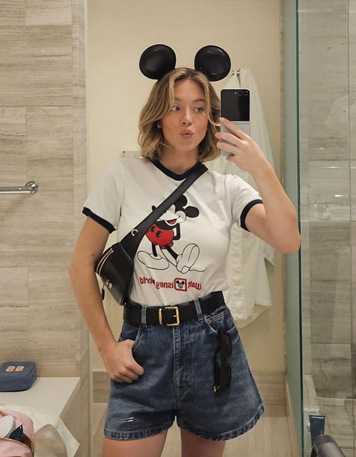 Person taking a mirror selfie wearing Mickey Mouse ears and a themed shirt. Person taking a mirror selfie wearing Mickey Mouse ears and a themed shirt.