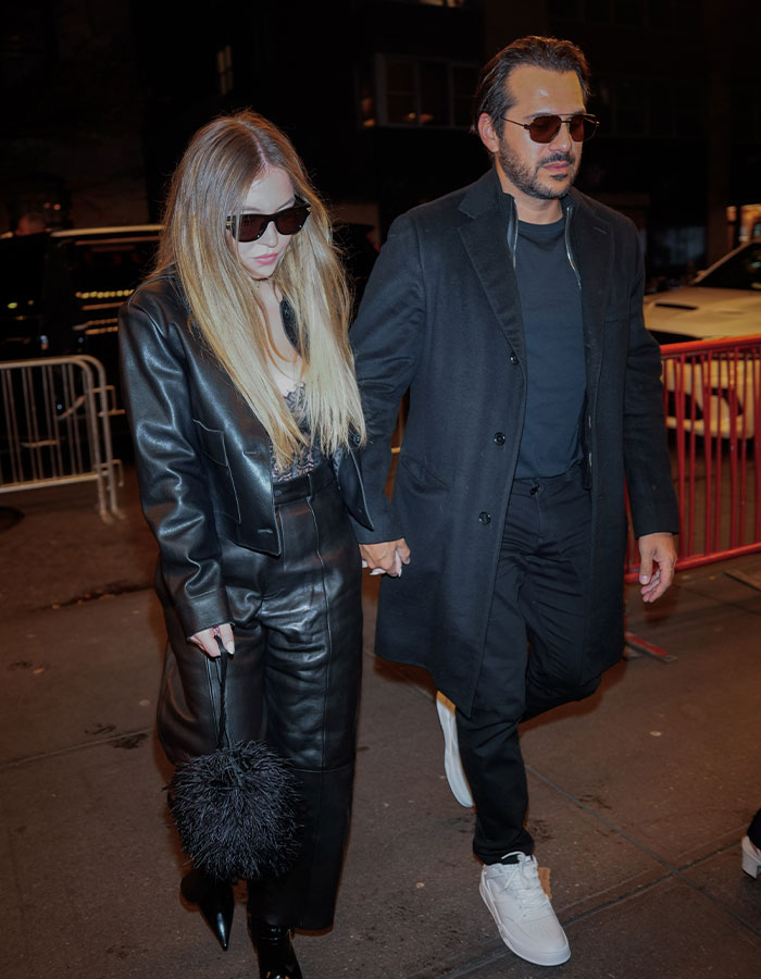 Couple in fashionable black attire walking, related to Sydney Sweeney and fiancé postponing their wedding. Couple in fashionable black attire walking, related to Sydney Sweeney and fiancé postponing their wedding.