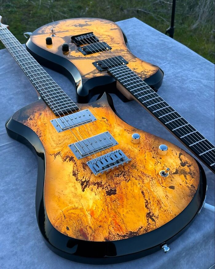 Stunning guitars with unique materials featuring vibrant, abstract designs on their bodies.