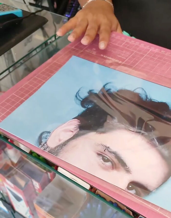 Prankster's hand holding a humorous photo in a playful family prank. Prankster's hand holding a humorous photo in a playful family prank.