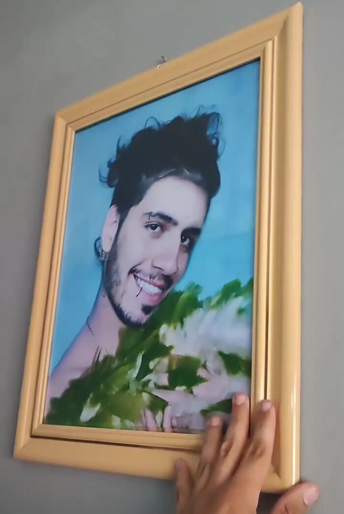 A framed photo of a smiling man holding greens, part of a funny prank on his family. A framed photo of a smiling man holding greens, part of a funny prank on his family.