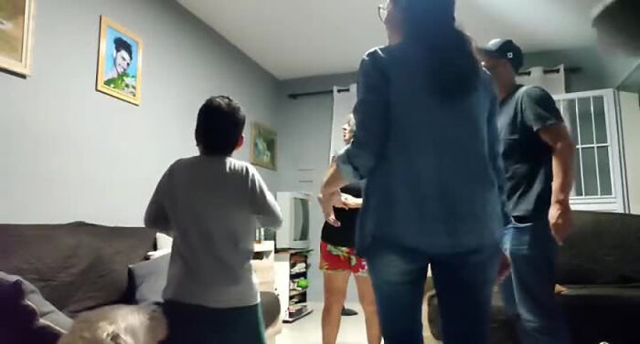 Family laughing in a living room during a prank, featuring playful interactions and a cozy atmosphere. Family laughing in a living room during a prank, featuring playful interactions and a cozy atmosphere.