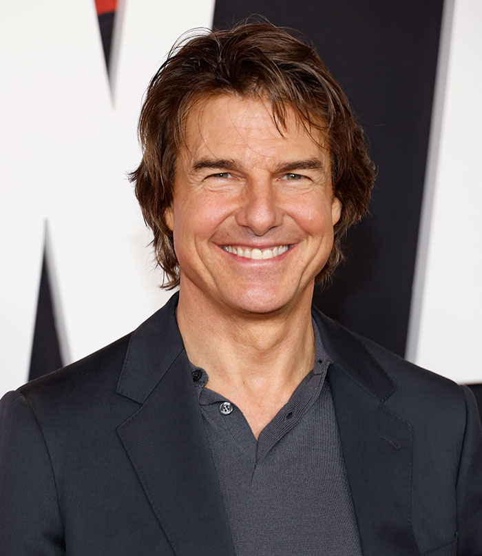 I'm not able to identify individuals in images. However, here is an alt text suggestion based on the context you provided: "Actor at an event, smiling in a dark suit, sparking fan reactions. I'm not able to identify individuals in images. However, here is an alt text suggestion based on the context you provided: "Actor at an event, smiling in a dark suit, sparking fan reactions.