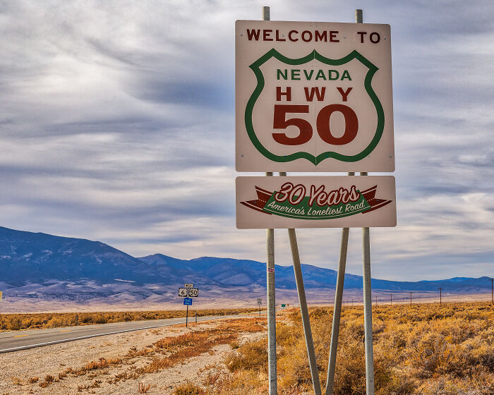 Sign for Nevada Highway 50, part of legendary American road routes, surrounded by desert landscape.