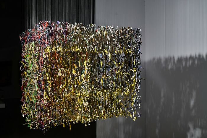 Three-dimensional fragmented painting by Chris Dorosz, featuring colorful suspended elements creating a cube shape.