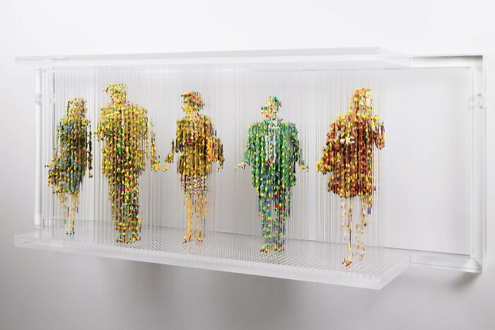 Three-dimensional painting of people by Chris Dorosz, featuring fragmented figures suspended in vertical layers.