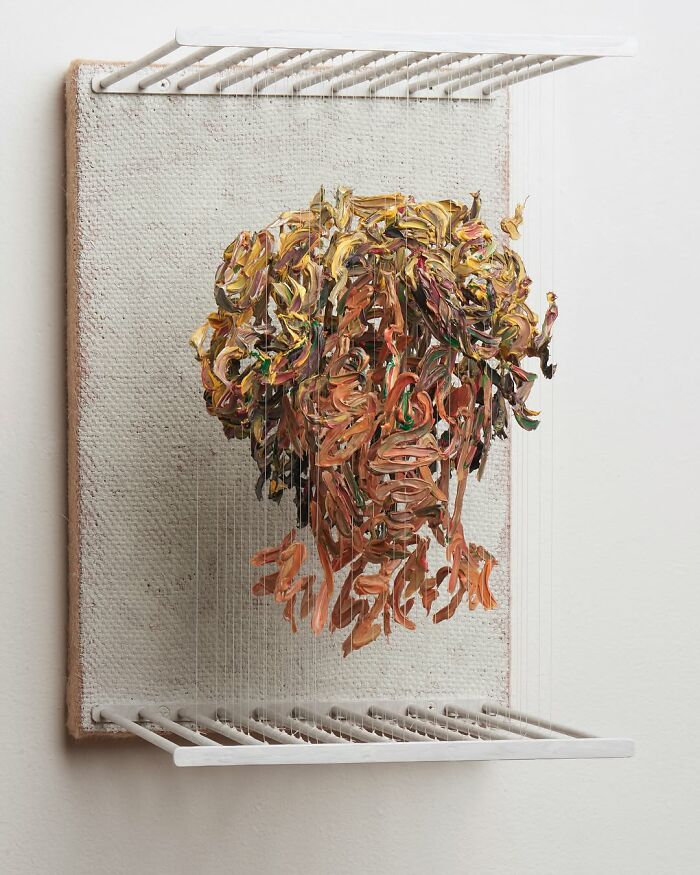 Three-dimensional, fragmented painting of a person's head by Chris Dorosz, featuring colorful brushstrokes on a canvas.