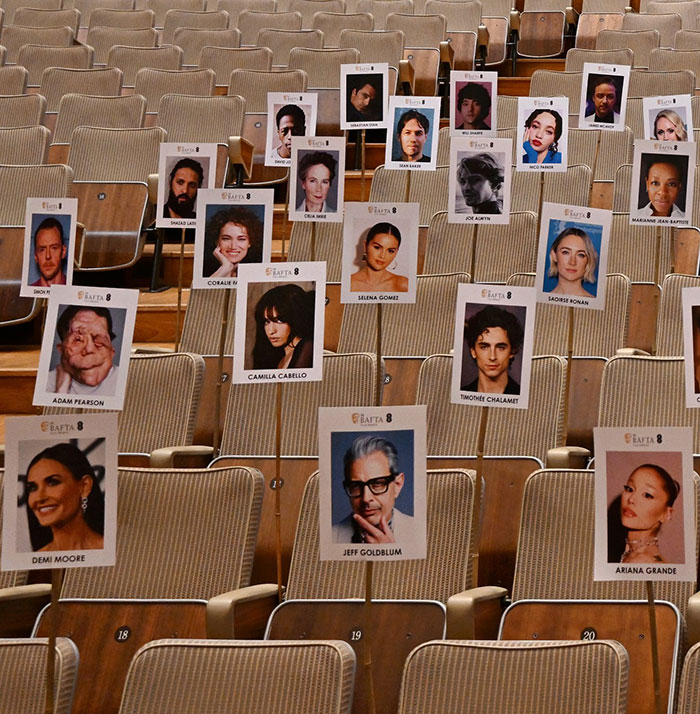 Empty auditorium with seats showing celebrity name cards, including Adam Pearson. Empty auditorium with seats showing celebrity name cards, including Adam Pearson.