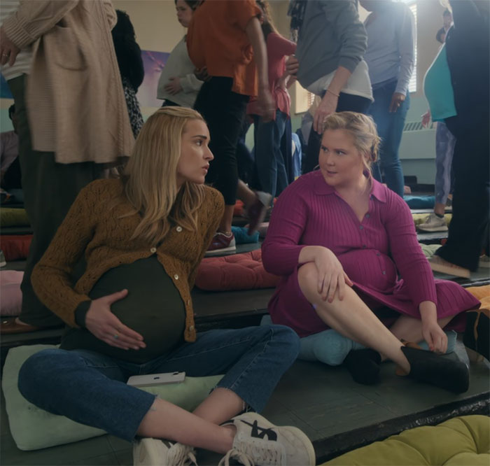 Two women sitting on floor cushions, discussing in a casual setting, related to comedy and viewer reactions. Two women sitting on floor cushions, discussing in a casual setting, related to comedy and viewer reactions.