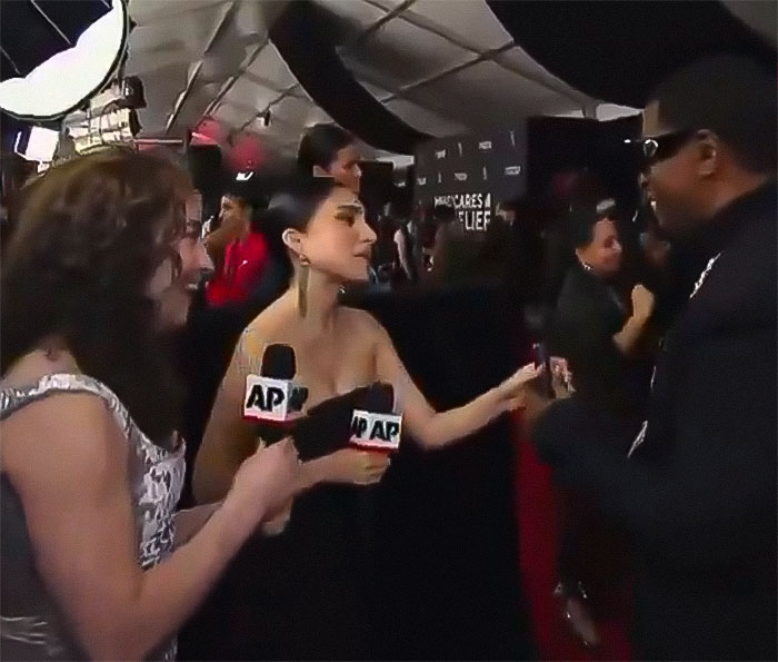 Reporters interviewing a person at the Grammys event. Reporters interviewing a person at the Grammys event.