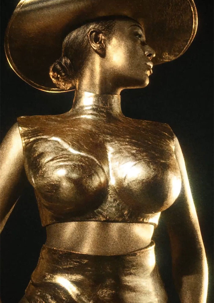 Gold-covered Beyonce in artistic pose wearing a hat, representing the criticized Ce Lumiere perfume ad. Gold-covered Beyonce in artistic pose wearing a hat, representing the criticized Ce Lumiere perfume ad.