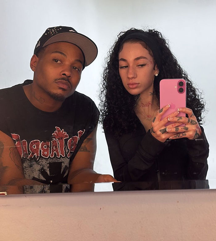 Two individuals posing in a mirror selfie, one holding a pink phone, linked to the keyword "47-Year-Old Mob Wife. Two individuals posing in a mirror selfie, one holding a pink phone, linked to the keyword "47-Year-Old Mob Wife.