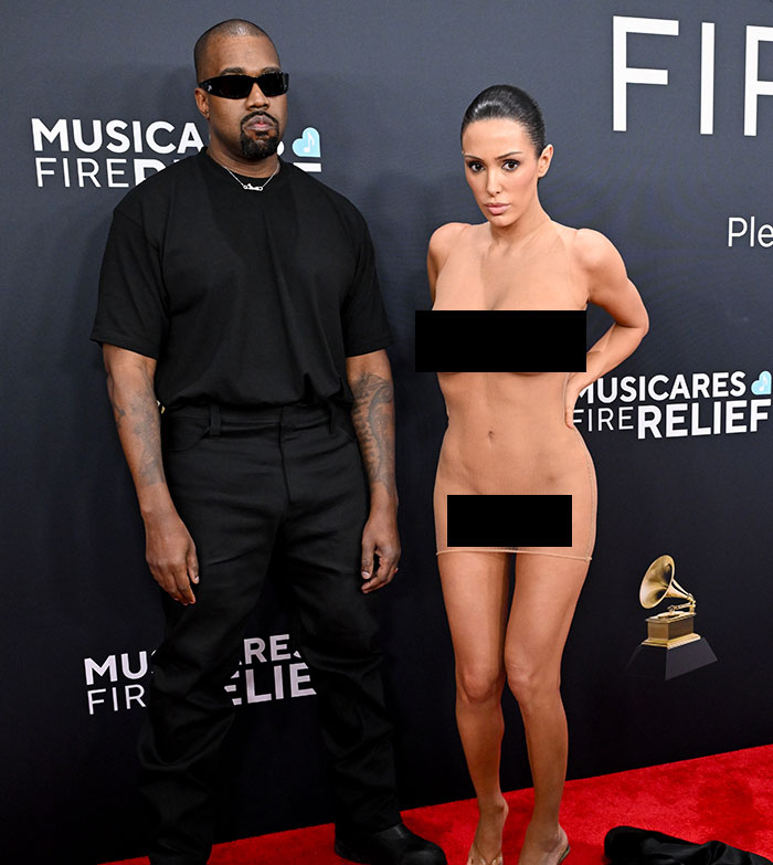 Bianca Censori in a revealing dress at the Grammys alongside a man in black, amid controversy. Bianca Censori in a revealing dress at the Grammys alongside a man in black, amid controversy.