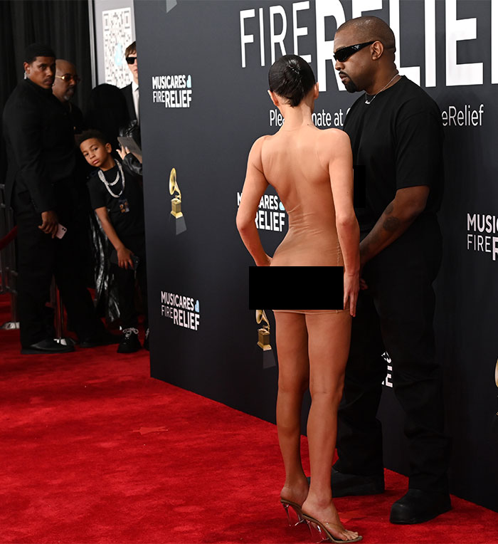 Child staring as Bianca Censori in bold ensemble at Grammys red carpet event. Child staring as Bianca Censori in bold ensemble at Grammys red carpet event.