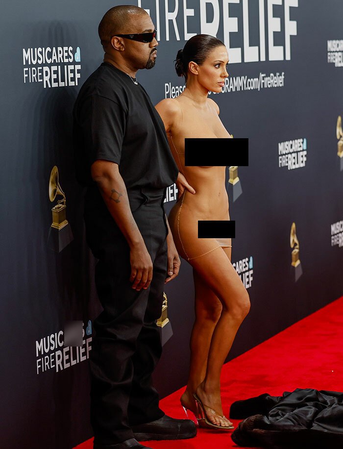 Man in black outfit and woman in minimal attire on red carpet, Bianca Censori second bare look afterparty event. Man in black outfit and woman in minimal attire on red carpet, Bianca Censori second bare look afterparty event.