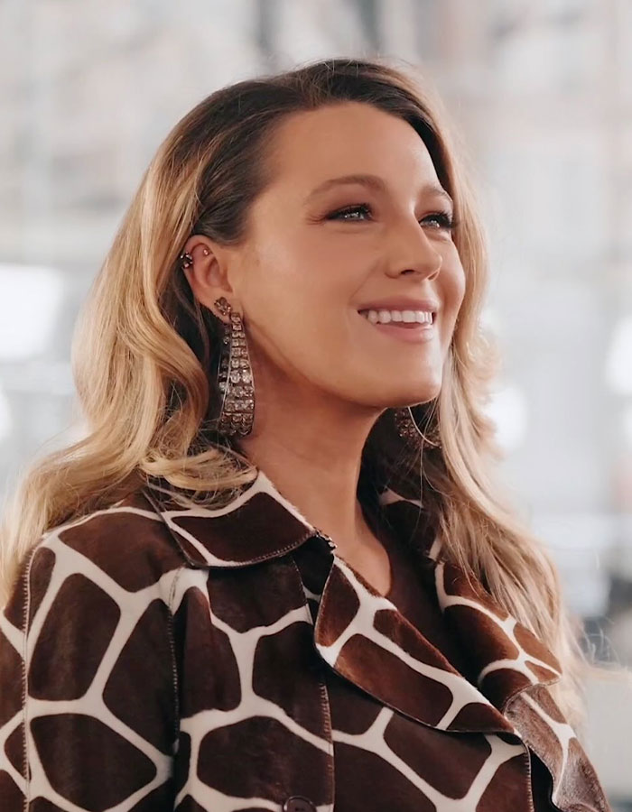 Smiling woman with long earrings, part of "It Ends With Us" behind-the-scenes discussion on Justin Baldoni's behavior. Smiling woman with long earrings, part of "It Ends With Us" behind-the-scenes discussion on Justin Baldoni's behavior.