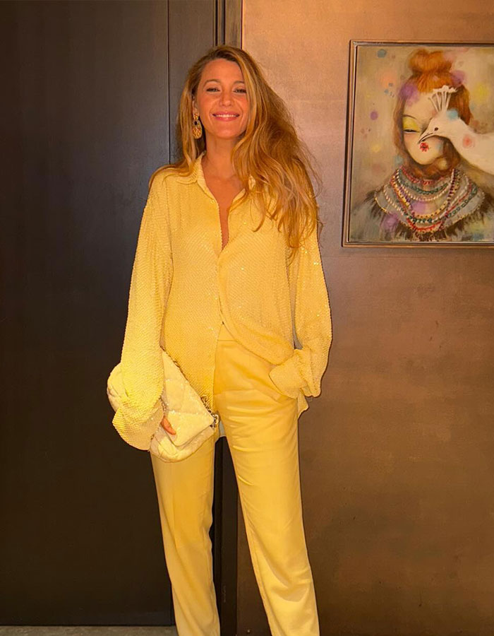 Blake Lively in a yellow outfit, smiling and posing indoors, with wall art in the background. Blake Lively in a yellow outfit, smiling and posing indoors, with wall art in the background.