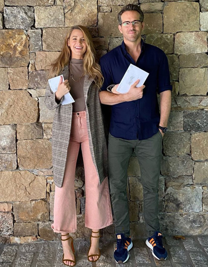 Two people standing against a stone wall, holding notebooks, related to Justin Baldoni's behavior during scenes. Two people standing against a stone wall, holding notebooks, related to Justin Baldoni's behavior during scenes.
