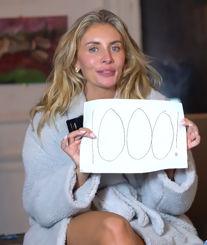 Bonnie Blue in a robe holds a sign with "1000!" written on it, sparking pregnancy rumors. Bonnie Blue in a robe holds a sign with "1000!" written on it, sparking pregnancy rumors.