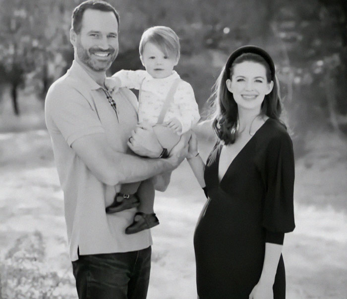 Family smiles outdoors; parents joyfully hold toddler after autism treatment success. Family smiles outdoors; parents joyfully hold toddler after autism treatment success.
