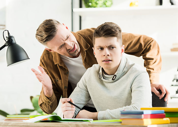 Teen looks upset while older man gestures, emphasizing a disagreement over brother's final words. Teen looks upset while older man gestures, emphasizing a disagreement over brother's final words.
