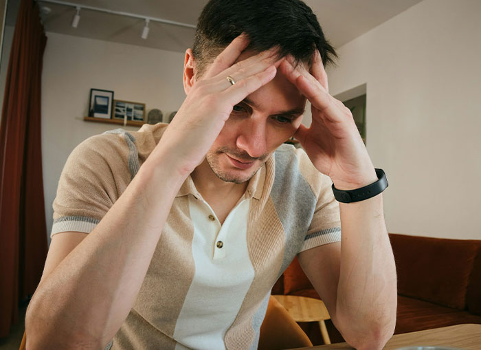 Man showing stress, resting head in hands, related to vasectomy discussion. Man showing stress, resting head in hands, related to vasectomy discussion.