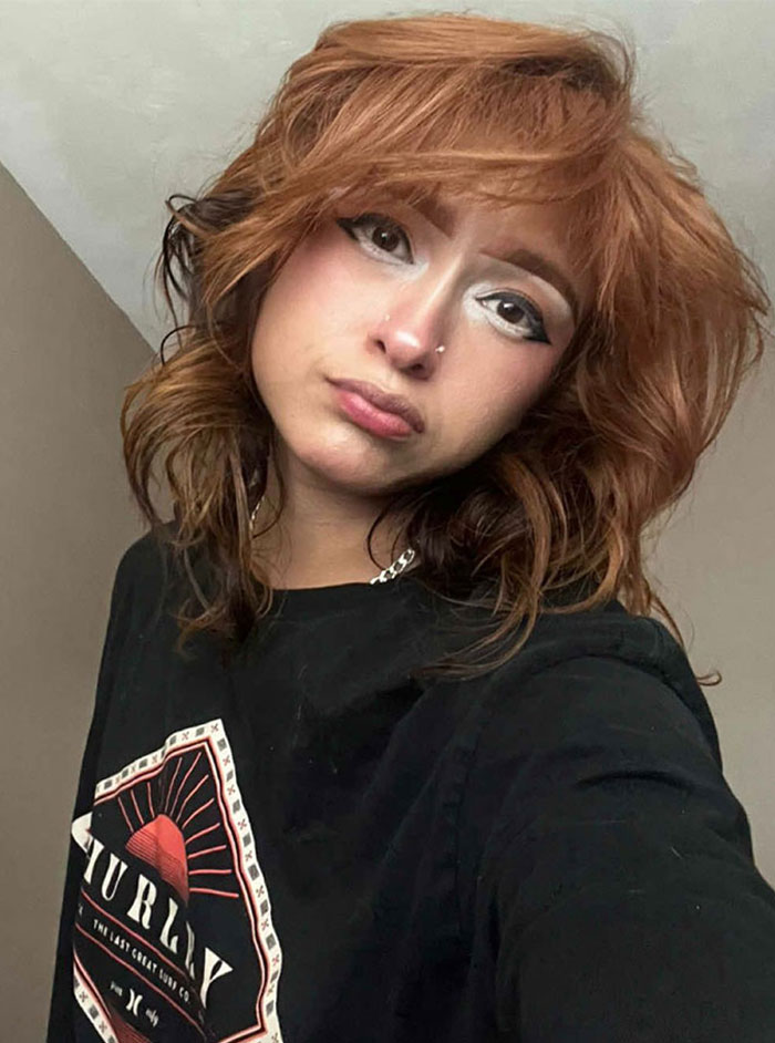 Single woman with auburn hair wearing a black shirt, showcasing a makeup style with glitter for protection on dates. Single woman with auburn hair wearing a black shirt, showcasing a makeup style with glitter for protection on dates.